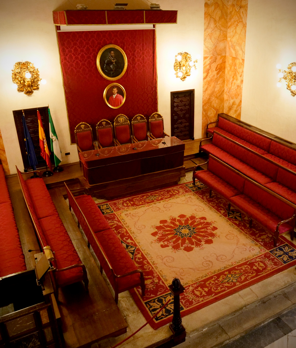 Imagen de los asientos de honor situados bajo el retrato del rey Felipe VI en el salón de actos institucional de la Facultad de Derecho