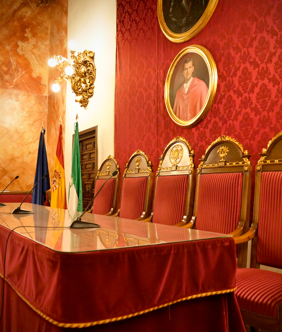 Imagen de los asientos de honor situados bajo el retrato del rey Felipe VI en el salón de actos institucional de la Facultad de Derecho