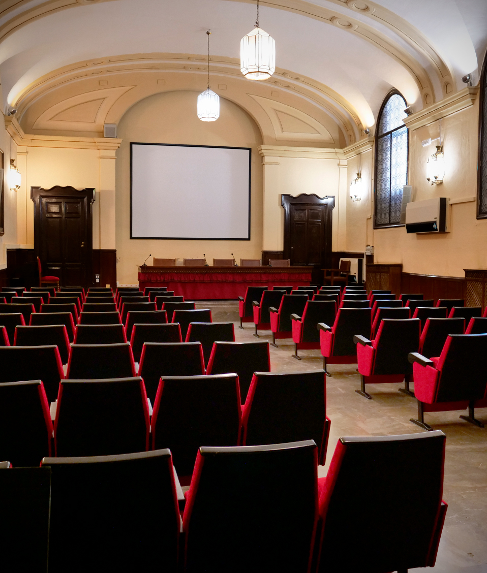 Salón de actos de la Facultad de Derecho, el espacio cuenta con diversos asientos así como con un proyector